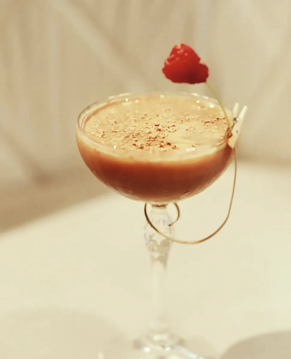 Creamy coffee cocktail with a raspberry garnish