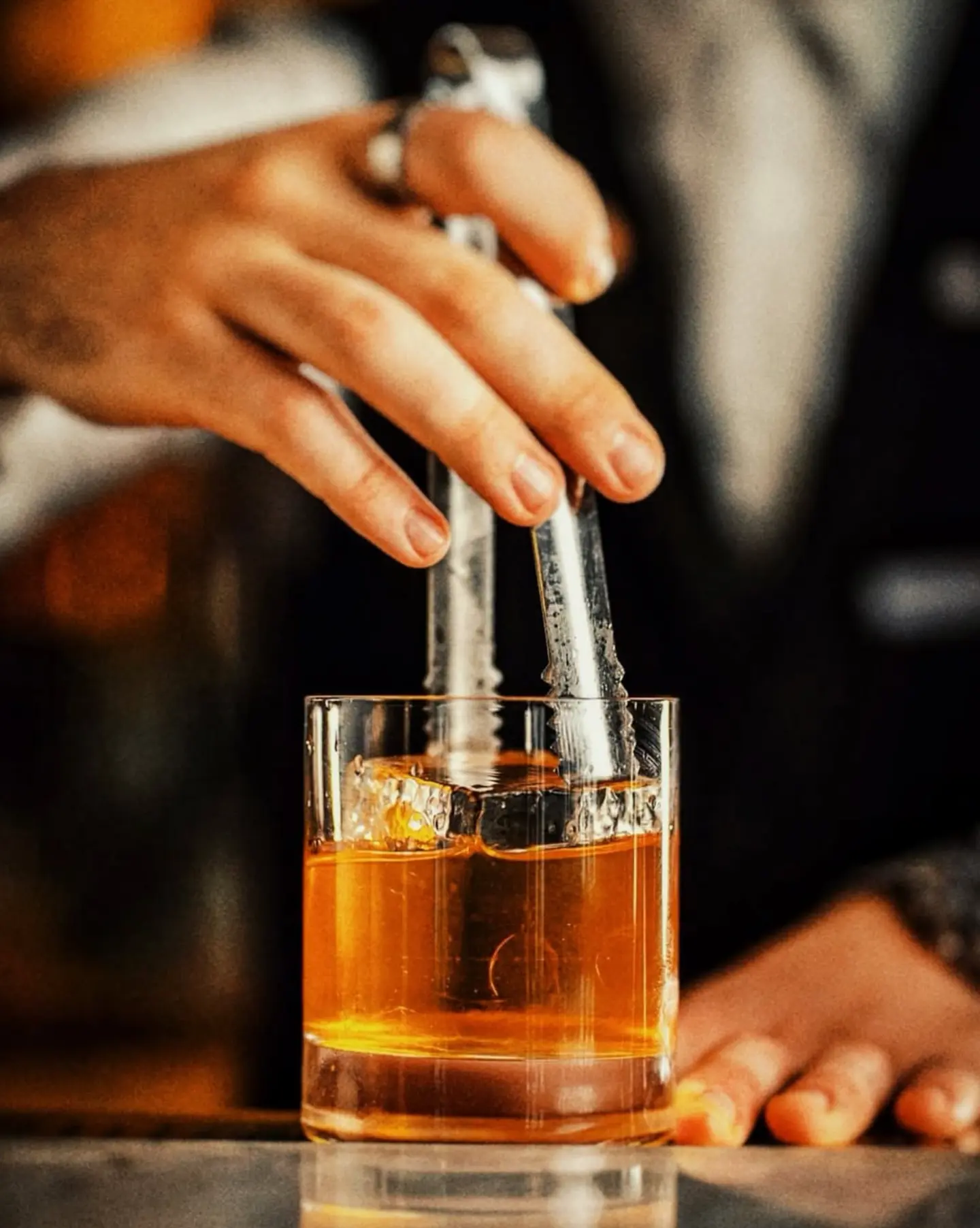 Bartender stirring a whisky cocktail