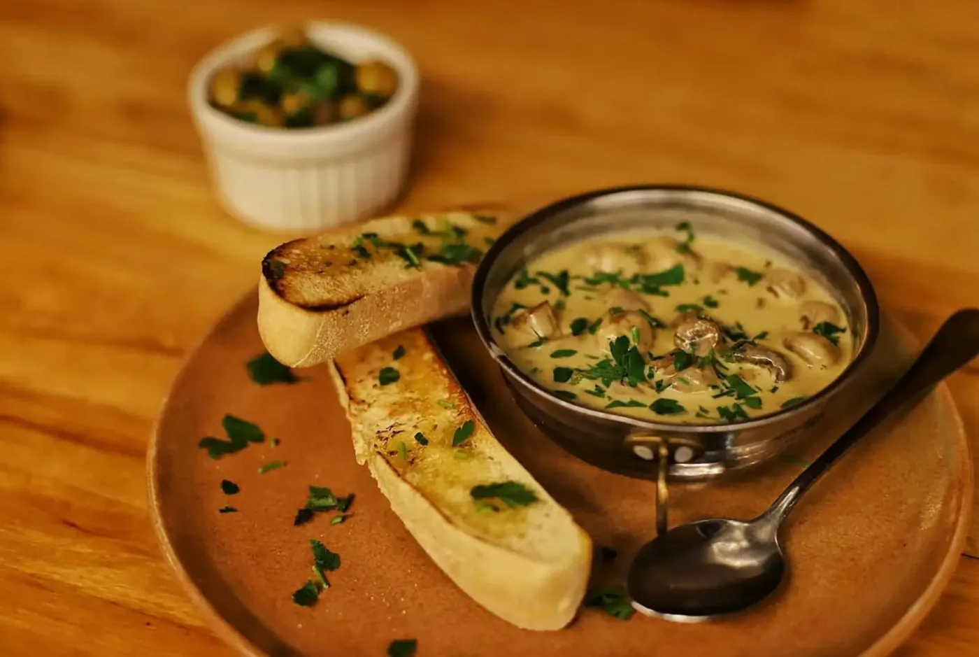 Creamy mushrooms with toasted bread and olives
