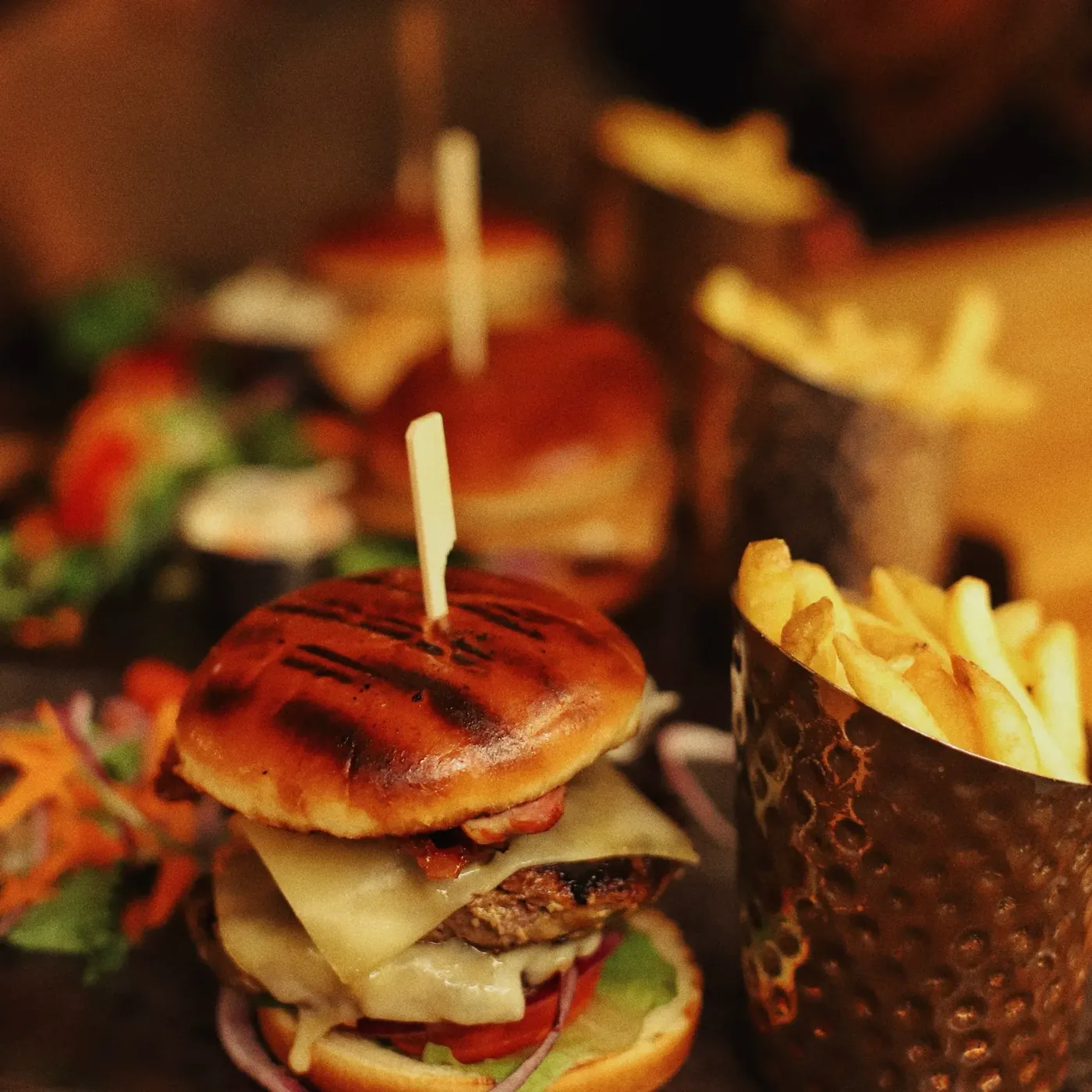 Burger with melted cheese, bacon and fries
