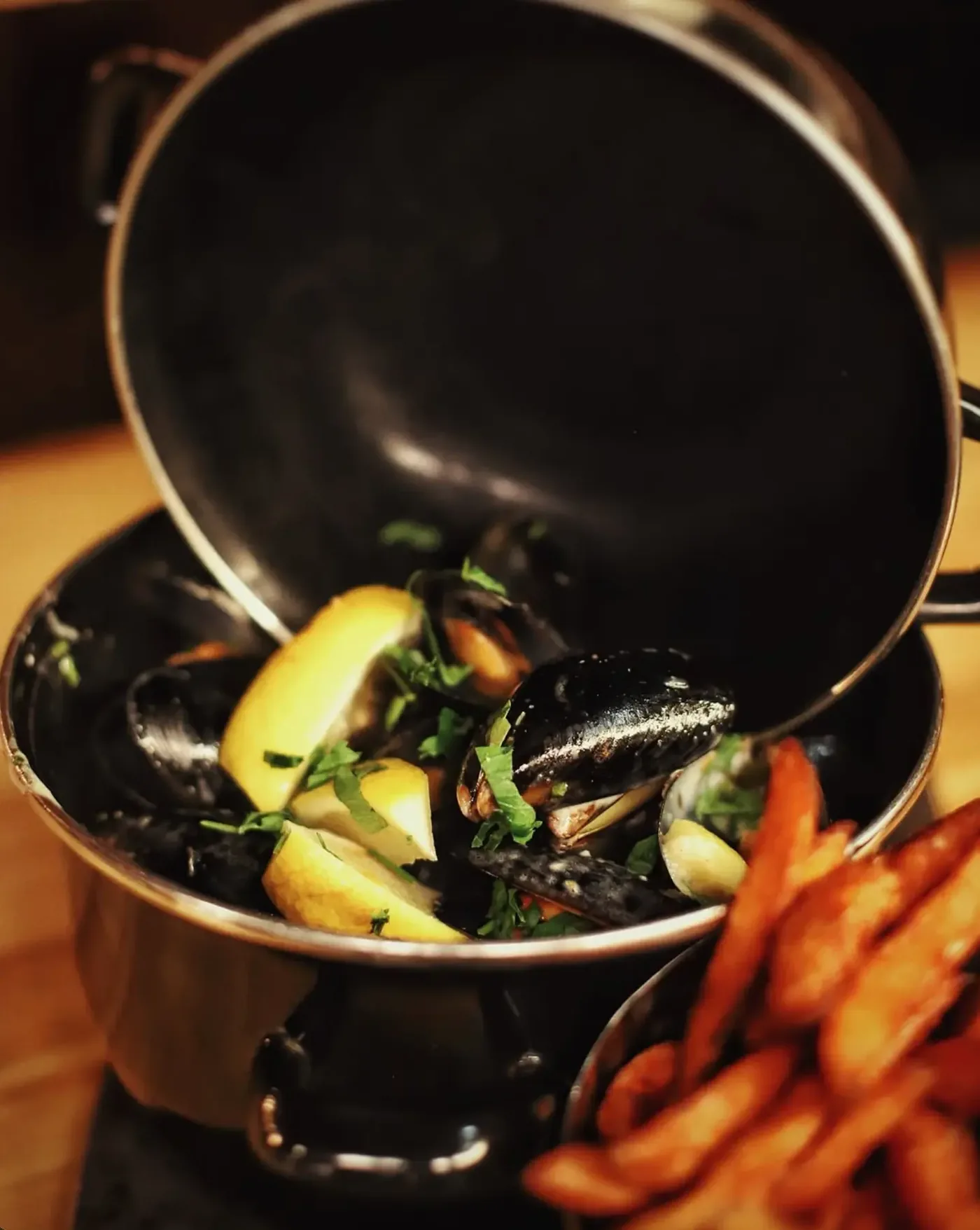 Mussels with lemon and parsley in a black pot